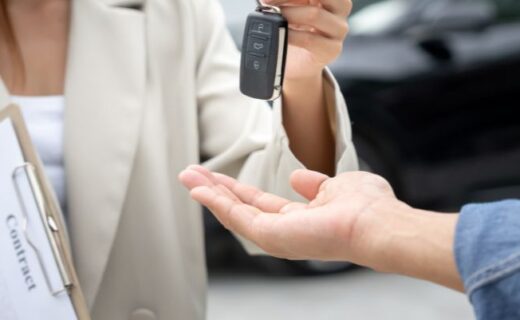 Pessoa entregando a chave de um carro durante a negociação de um veículo