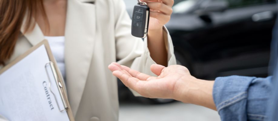 Pessoa entregando a chave de um carro durante a negociação de um veículo